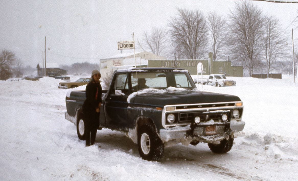 John Iacoangeli, brother of Ford customer Paul Iacoangeli, is standing next to his 1976 F-100 after a 1978 blizzard. The brothers waited in Erie to pick up people stranded and needing to get back to Monroe. Pam Iacoangeli, Paul's former sister in law, is in the truck.