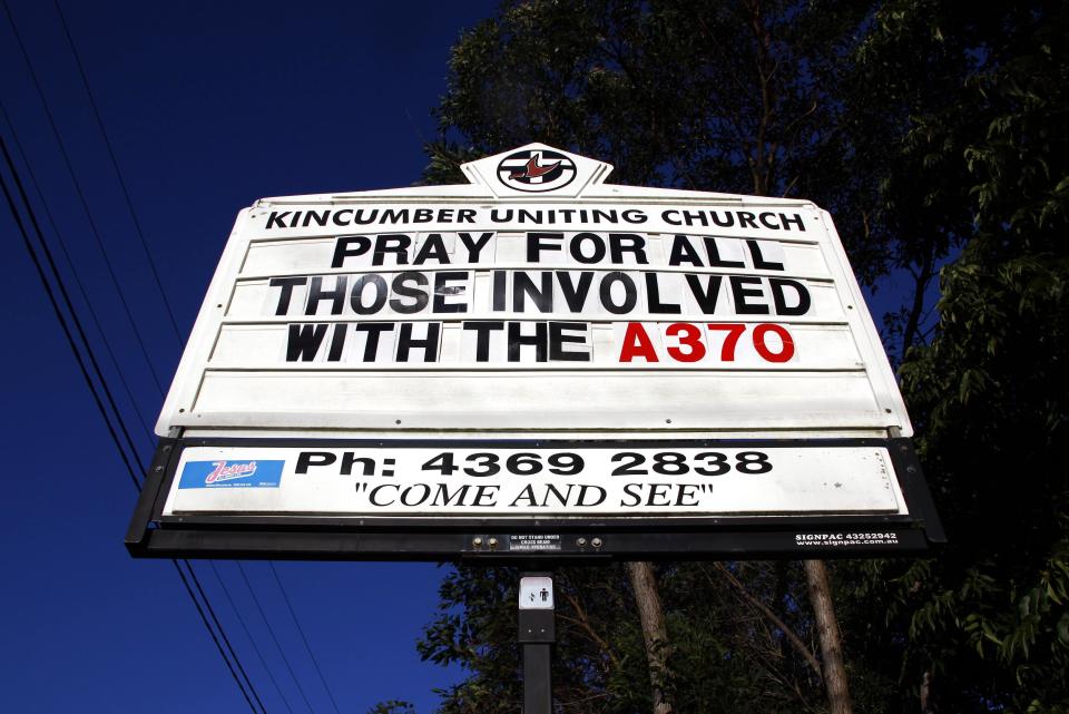 A sign displays a message regarding the search for the missing Malaysian Airlines Flight MH370 outside the Uniting Church in the town of Kincumber