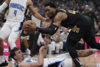 Orlando Magic forward Franz Wagner, bottom left, fouls Cleveland Cavaliers guard Donovan Mitchell, right, and falls to the floor in the first half of Game 7 of an NBA basketball first-round playoff series Sunday, May 5, 2024, in Cleveland. (AP Photo/Sue Ogrocki)