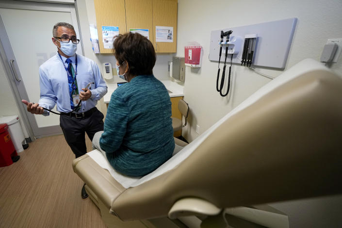 Nurse practitioner Anthony Carano speaks with a patient at the Mountain Park Health Center, Thursday, March 30, 2023, in Phoenix. As heat waves fueled by climate change arrive earlier, grow more intense and last longer, people over 60 who are more vulnerable to high temperatures are increasingly at risk of dying from heat-related causes. Heat related deaths are challenging community health systems, utility companies, apartment managers and local governments to better protect older people when temperatures soar.(AP Photo/Matt York)