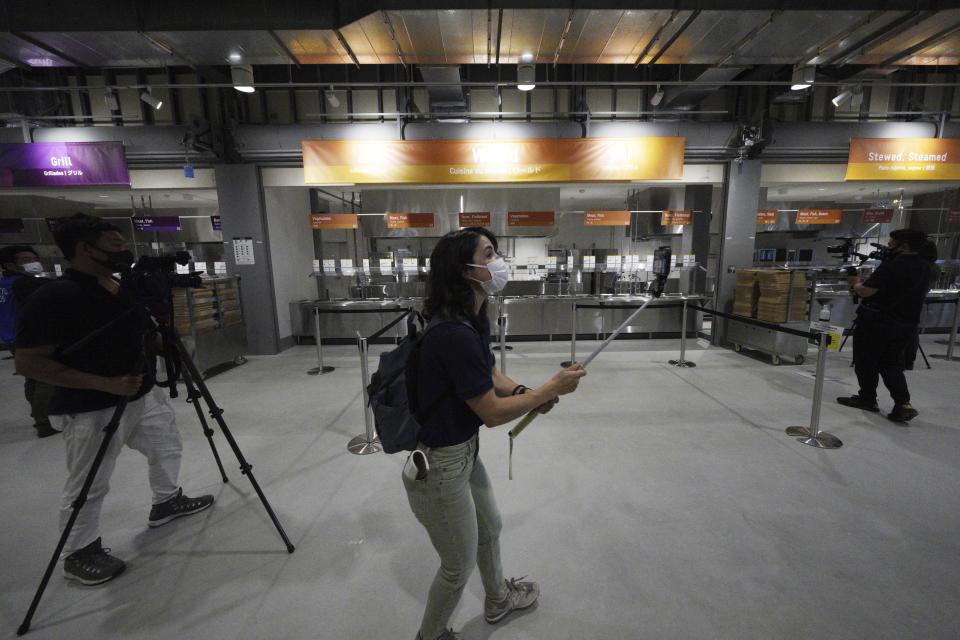 Journalists film the main dining hall during a press tour of the Tokyo 2020 Olympic and Paralympic Village Sunday, June 20, 2021, in Tokyo. (AP Photo/Eugene Hoshiko)