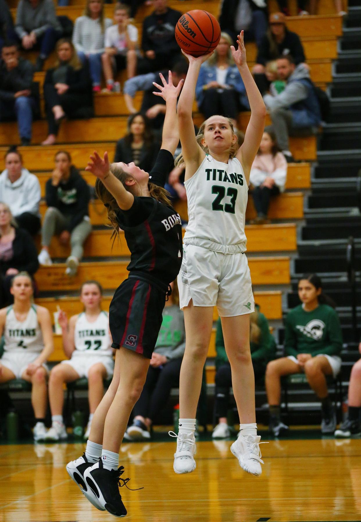 West Salem's Lizzy Bennett, 23, goes up for a basket against Sherwood's Laney Snelling, 1,  during their OSAA girls basketball state playoff game at West Salem High School March 3, 2020, in Salem. The West Salem Titans won the game to advance to the next round.