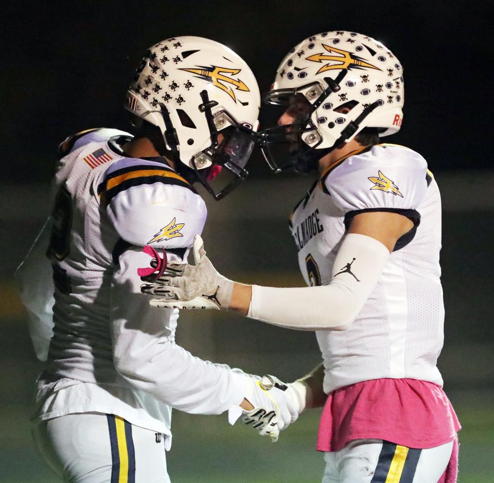 Tallmadge wide receiver Collin Dixon, left, shakes hands with teammate Mason Dexter after scoring during the first half of a high school football game against the Copley Indians, Friday, Oct. 15, 2021, in Copley, Ohio.