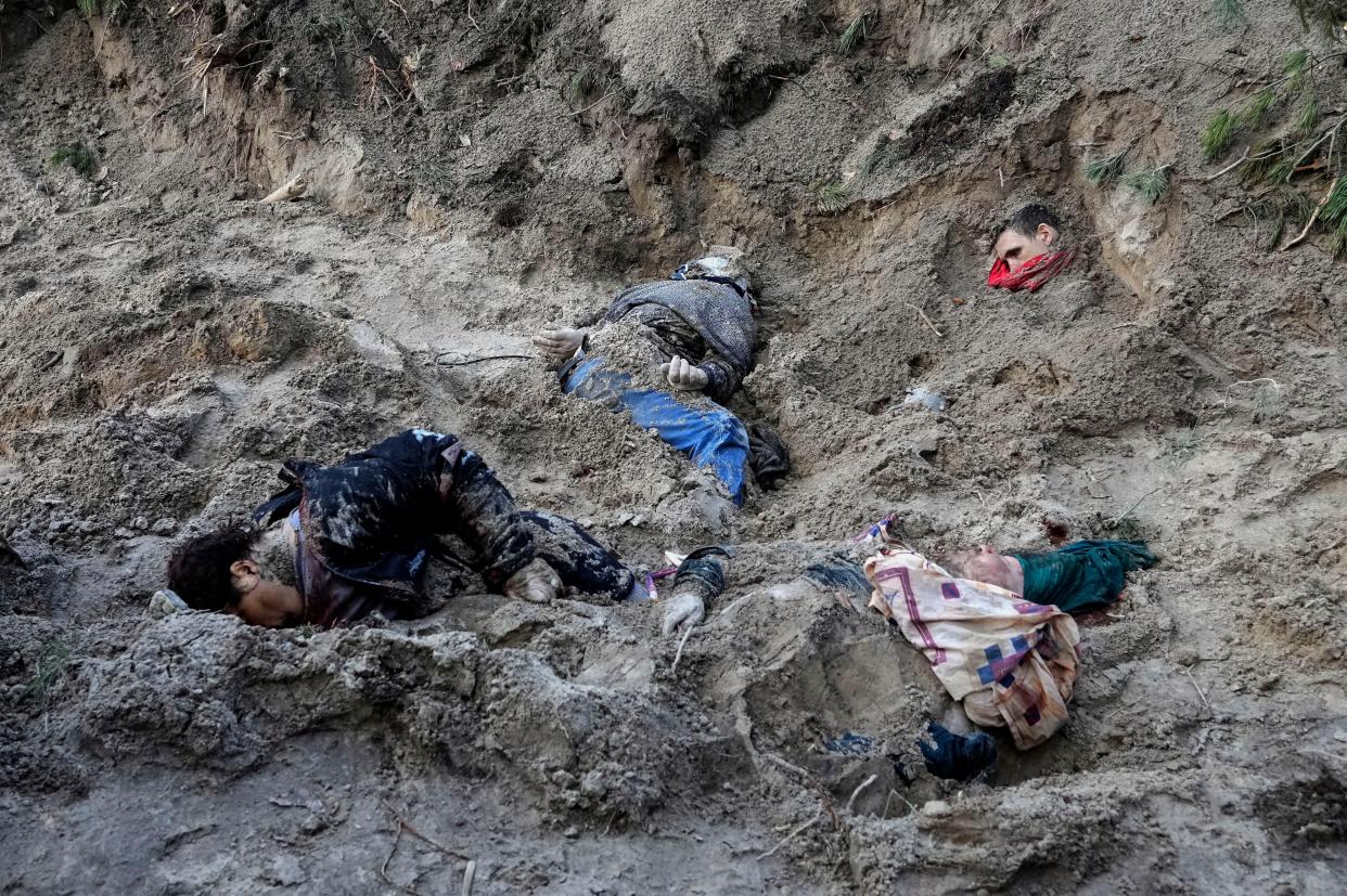 Four bodies lie in a mass grave, including the village mayor and her family, in Motyzhyn close to Kyiv, Ukraine, Monday, April 4, 2022, after Russian army were pushed out from the area by Ukrainian forces. 