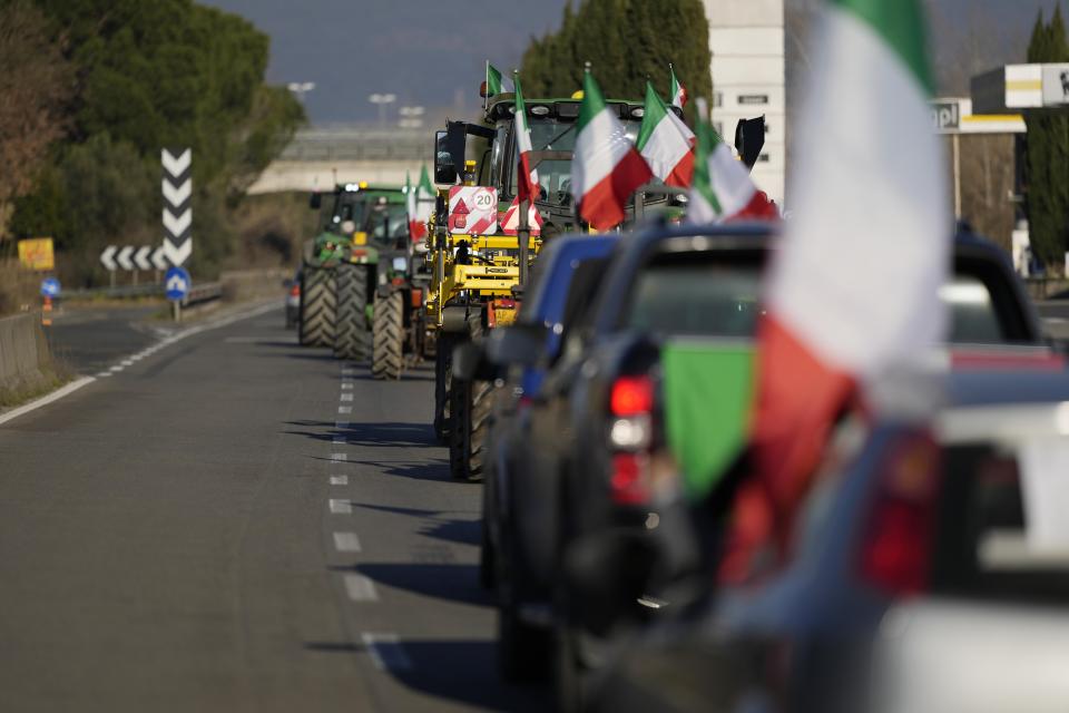 Farmers line up with their tractors on the high speed road in Orte, Italy, Wednesday, Jan. 31, 2024. Farmers have been protesting in various parts of Italy and Europe against EU agriculture policies. (AP Photo/Andrew Medichini)