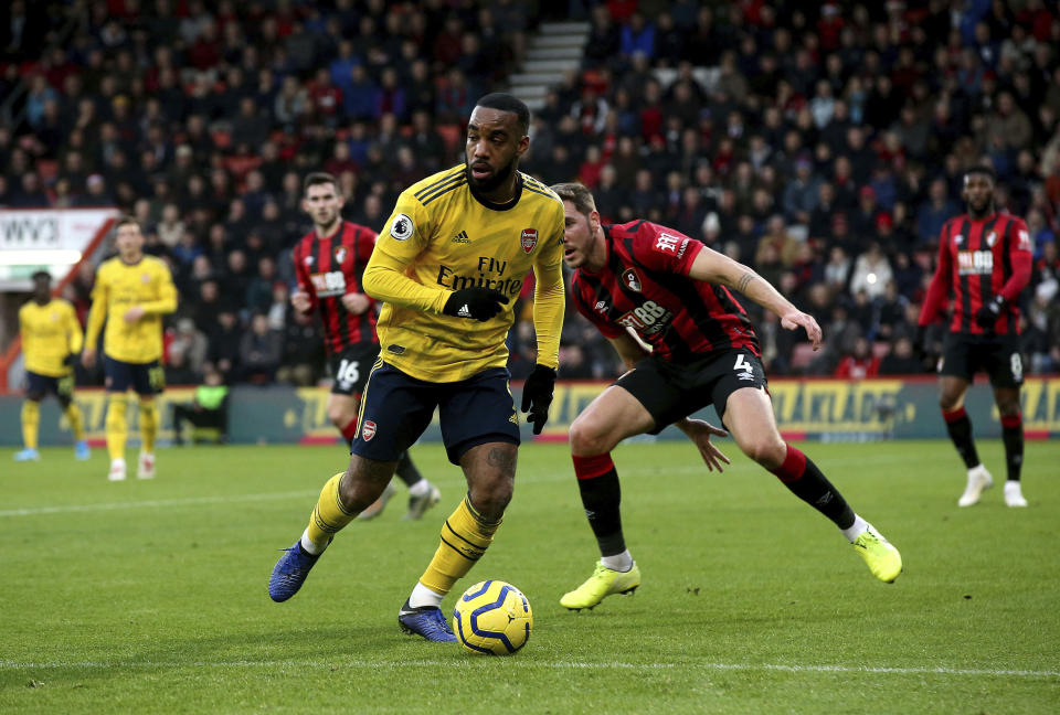 Arsenal's Alexandre Lacazette, front, takes the ball from Bournemouth's Dan Gosling during their English Premier League soccer match at the Vitality Stadium, Bournemouth, England, Thursday, Dec. 26, 2019. (Mark Kerton/PA via AP)