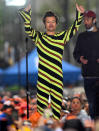 <p>Harry Styles performs on <em>Today </em>in N.Y.C. wearing a neon green, brown and black striped jumpsuit on May 19. </p>