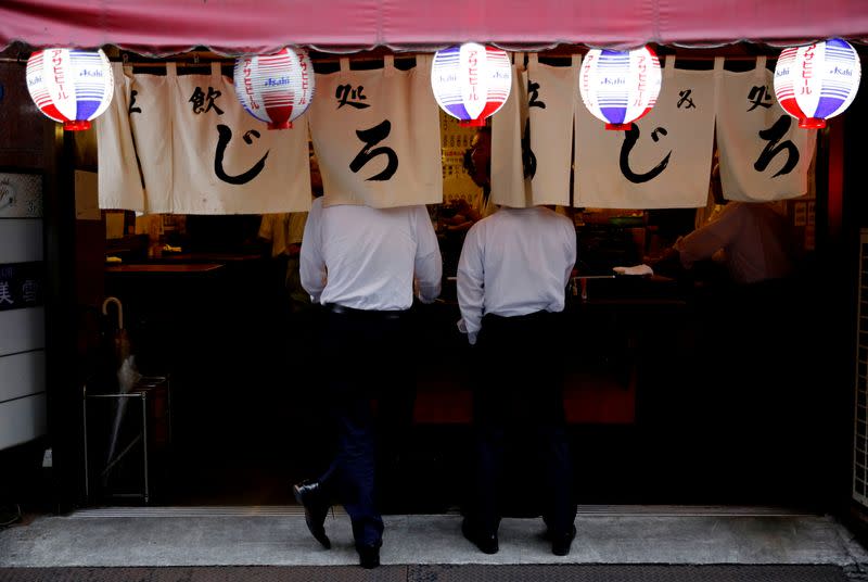 Men drink at a traditional bar after work in Tokyo