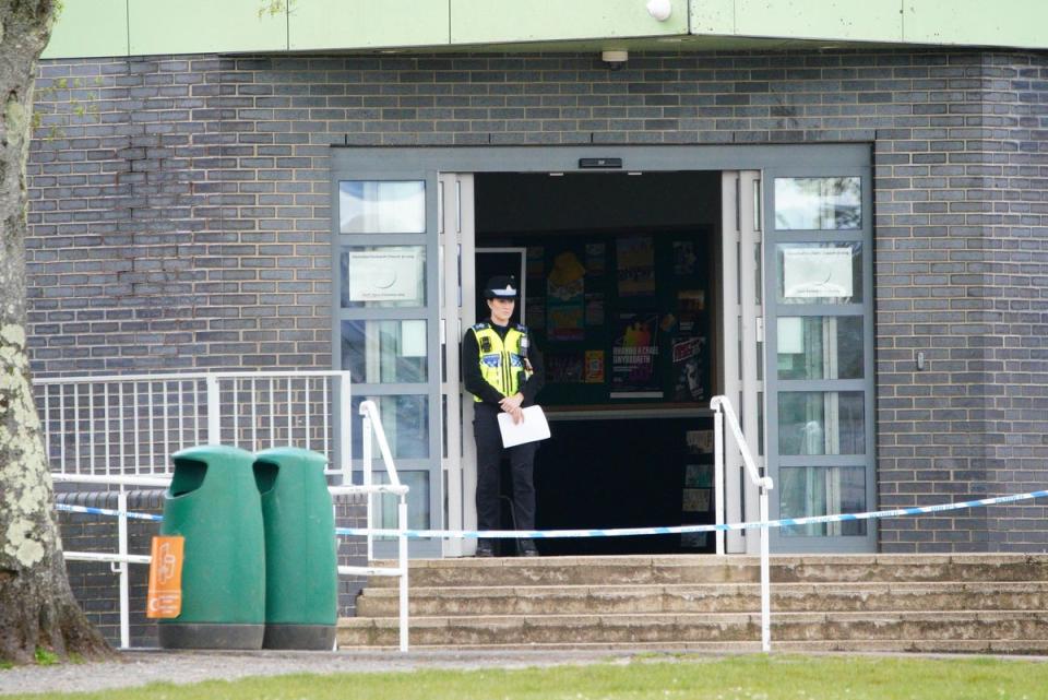 A police officer stands at the entrance to Amman Valley school (Ben Birchall/PA Wire)