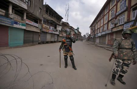 Indian security personnel stand guard along a deserted street during restrictions in Srinagar, November 6, 2015. REUTERS/Danish Ismail