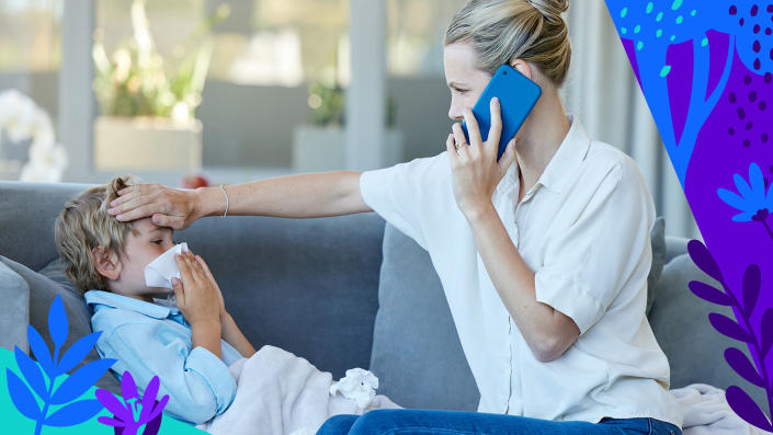 A mom on the phone feels the forehead of her child who seems to have a cold or allergies.