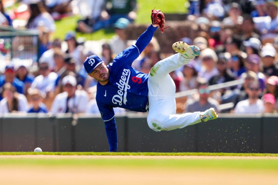 Los Angeles Dodgers second baseman Gavin Lux falls while trying to field a single hit by Arizona Diamondbacks' Geraldo Perdomo during the fourth inning of a spring training baseball game Sunday, March 10, 2024, in Phoenix.