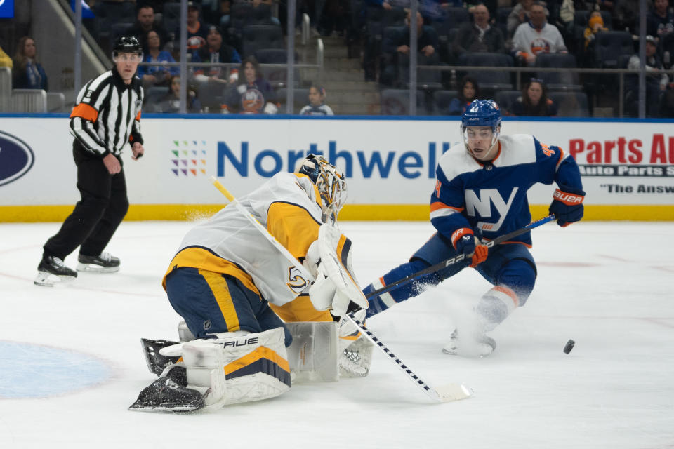 Nashville Predators goaltender Kevin Lankinen, front left, saves a shot from New York Islanders center Jean-Gabriel Pageau, right, during the second period of an NHL hockey game in Elmont, N.Y., Saturday, April 6, 2024. (AP Photo/Peter K. Afriyie)