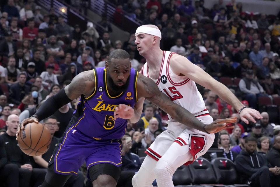 Los Angeles Lakers' LeBron James drives to the basket as Chicago Bulls' Alex Caruso defends during the first half of an NBA basketball game, Wednesday, March 29, 2023, in Chicago. (AP Photo/Charles Rex Arbogast)