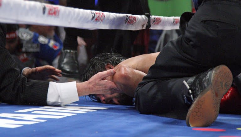 Hands reach in ringside to support the head of Manny Pacquiao after he was knocked out by Juan Manuel Marquez. There was initial concern for the Filipino's wellbeing, but he eventually climbed off the floor. Pacquiao did not attend the post-fight news conference. His camp said he was undergoing scans of his head area and other medical tests