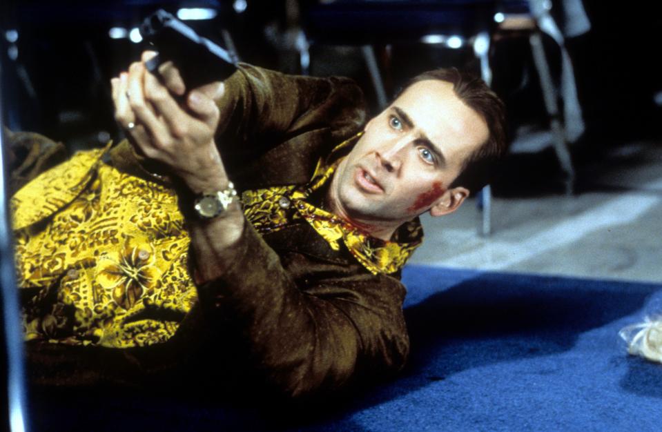 Nicolas Cage pointing a gun in a scene from the film 'Snake Eyes', 1998. (Photo by Paramount Pictures/Getty Images)