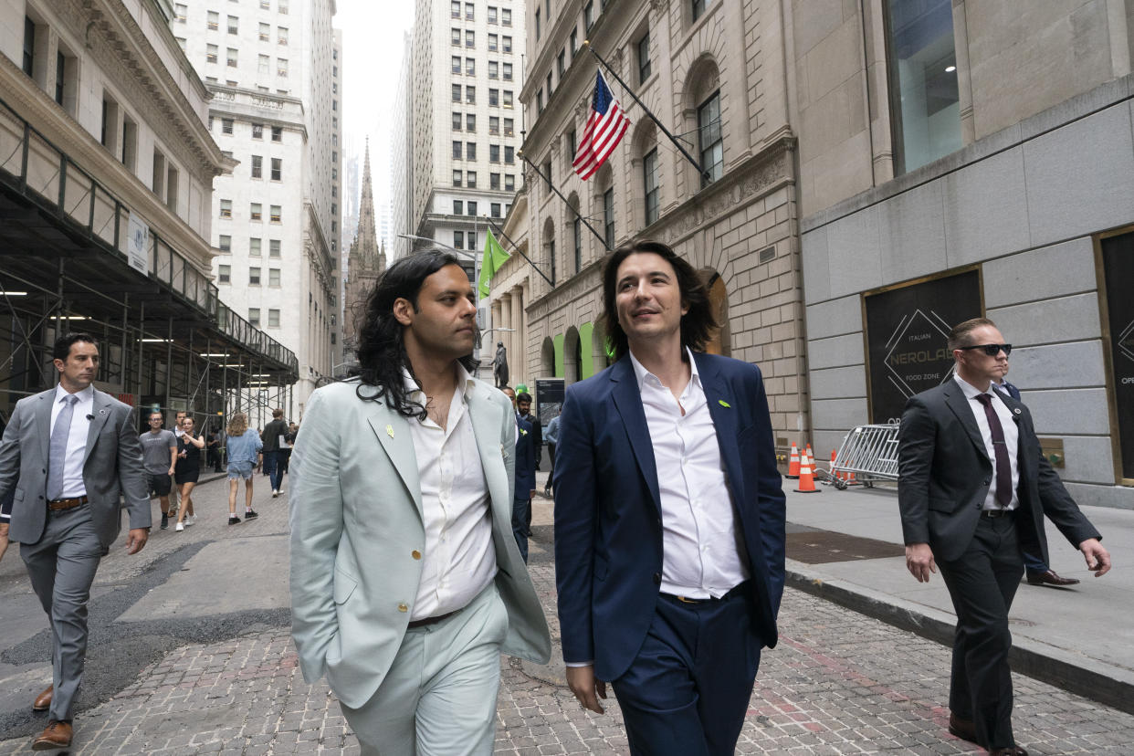 Baiju Bhatt, left, and Vladimir Tenev, Co-Founders of Robinhood, walk on Wall Street following their company's IPO at Nasdaq, Thursday, July 29, 2021 in New York. Robinhood is selling its own stock on Wall Street, the very place the online brokerage has rattled with its stated goal of democratizing finance. Through its app, Robinhood has introduced millions to investing and reshaped the brokerage industry, all while racking up a long list of controversies in less than eight years. (AP Photo/Mark Lennihan)