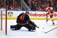 Calgary Flames forward Matthew Tkachuk, right, looks on as Edmonton Oilers goalie Mike Smith deflects his shot during the first period of an NHL hockey Stanley Cup second-round playoff series game in Edmonton, Alberta, Sunday, May 22, 2022. (Jeff McIntosh/The Canadian Press via AP)