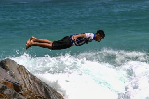 A youngster dives into the sea at Camurichico beach in La Guaira