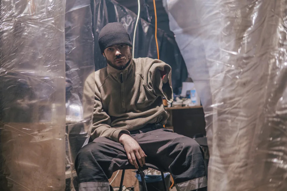 In this photo provided by Azov Special Forces Regiment of the Ukrainian National Guard Press Office, an Azov Special Forces Regiment's serviceman, injured during fighting against Russian forces, poses for a photographer inside the Azovstal steel plant in Mariupol, Ukraine, Tuesday, May 10, 2022. (Dmytro 'Orest' Kozatskyi/Azov Special Forces Regiment of the Ukrainian National Guard Press Office via AP)