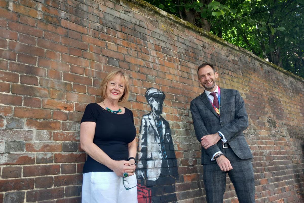 Former headteacher Kay Mountfield (left) and current headteacher Ed Goodall (right) pose with the artwork outside Sir William Borlase's Grammar School in Marlow <i>(Image: NQ)</i>