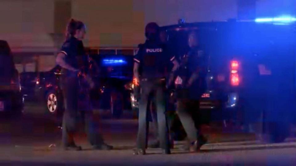 PHOTO: Police officers cordon off a crime scene at the Logan Square Mall in Lansing on July 30, 2023, after a shooting left five people injured, two in critical condition. (WLAJ-TV)