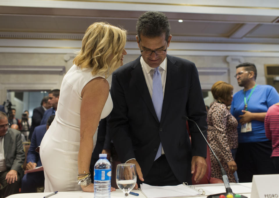 Proposed Secretary of State Pedro Pierluisi listens to his sister and spokesperson Caridad Pierluisi during a break in his confirmation hearing at the House of Representatives, in San Juan, Puerto Rico, Friday, August 2, 2019. As Gov. Ricardo Rossello is expected to leave office in a few hours, the Puerto Rican House of Representatives is expected to vote on Pierluisi's confirmation Friday afternoon. If he is rejected, Justice Secretary Wanda Vazquez automatically becomes governor as the next in the order of succession, even though she has said she would unwillingly accept the job. (AP Photo/Dennis M. Rivera Pichardo)