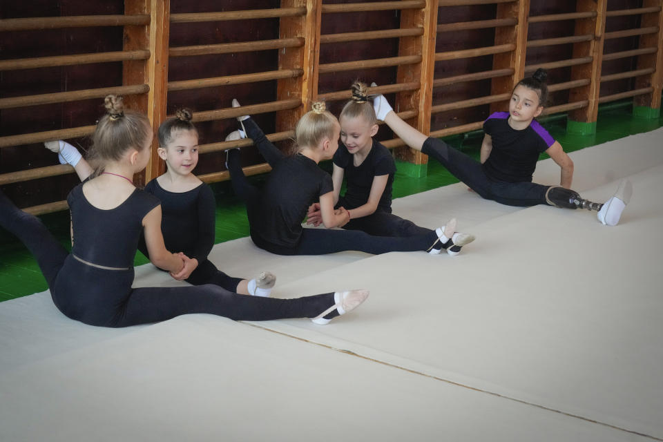 Oleksandra Paskal, an 8-year old girl with a prosthetic leg, practices rhythmic gymnastics with other girls in Chornomorsk, Odesa region, Ukraine, Thursday, May 16, 2024. When Oleksandra first took to the mat as a 4-year-old, her rhythmic gymnastics coach saw nothing but potential in a sport where the Olympics is the ultimate goal. Then a Russian missile crushed her summer house in the southern Odesa region, burying her beneath the debris and severing her left leg. (AP Photo/Efrem Lukatsky)