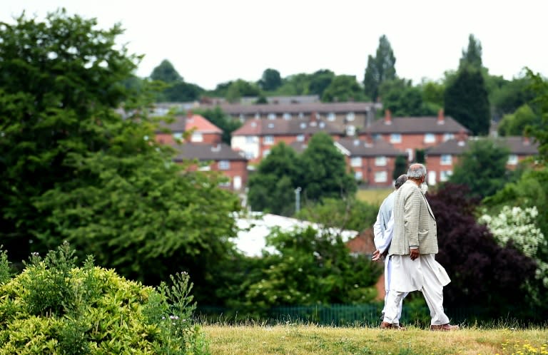 People walk in a park in Savile Town, Dewsbury on July 5, 2015