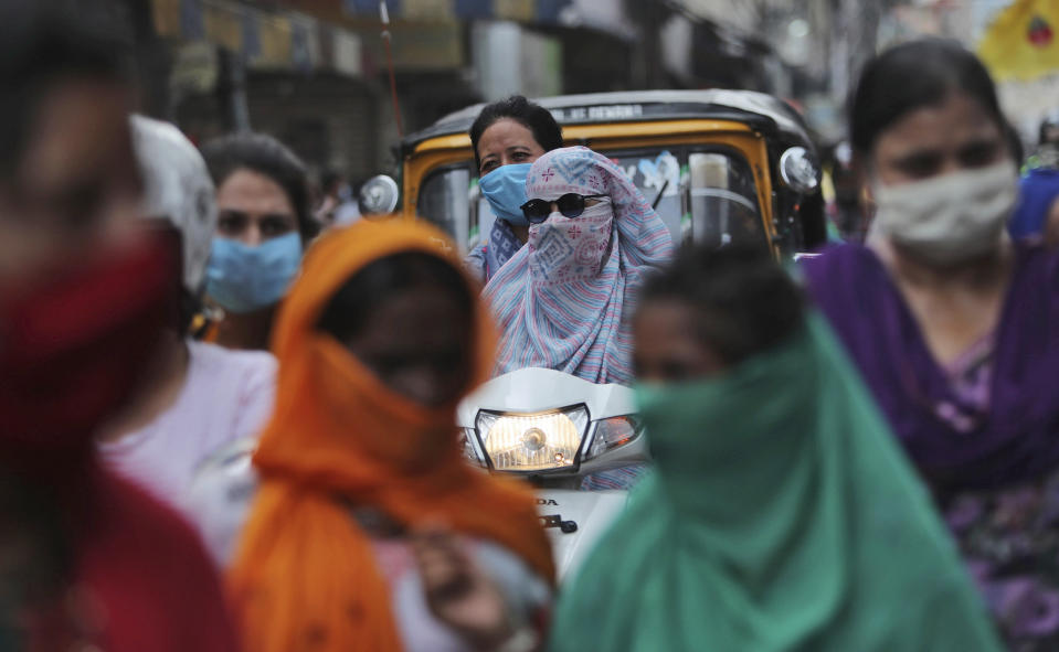 Indians wearing face masks as a precaution against the coronavirus walk at a market in Jammu, India, Monday, Aug 10, 2020. India is the third hardest-hit country by the pandemic in the world after the United States and Brazil. (AP Photo/Channi Anand)