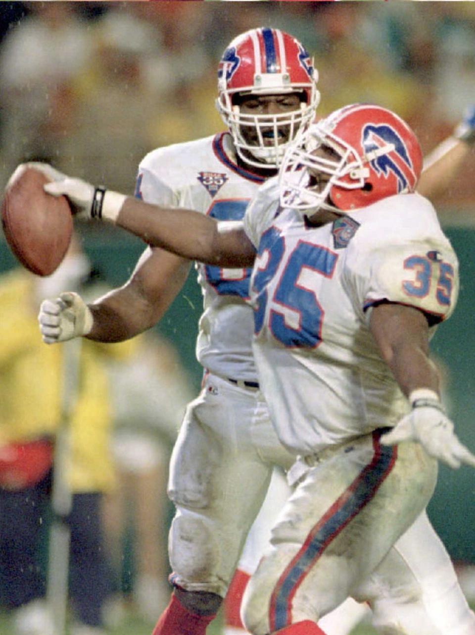 Buffalo Bills running back Cardwell Gardner celebrates his third quarter touchdown with teammate Corbin Lacina against the Miami Dolphins in Miami on Dec. 4, 1994. The Bills defeated the Dolphins, 42-31.