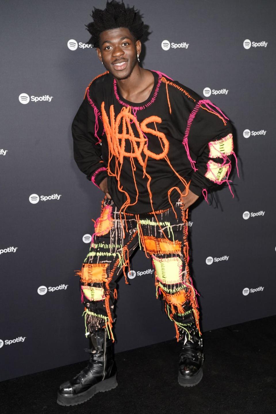 <p>He stepped into Spotify's Best New Artist party just radiating cool. Lil Nas X traded in his cowboy boots for some chunky combat boots, and wore this neon fringe look with his name on the top. </p>