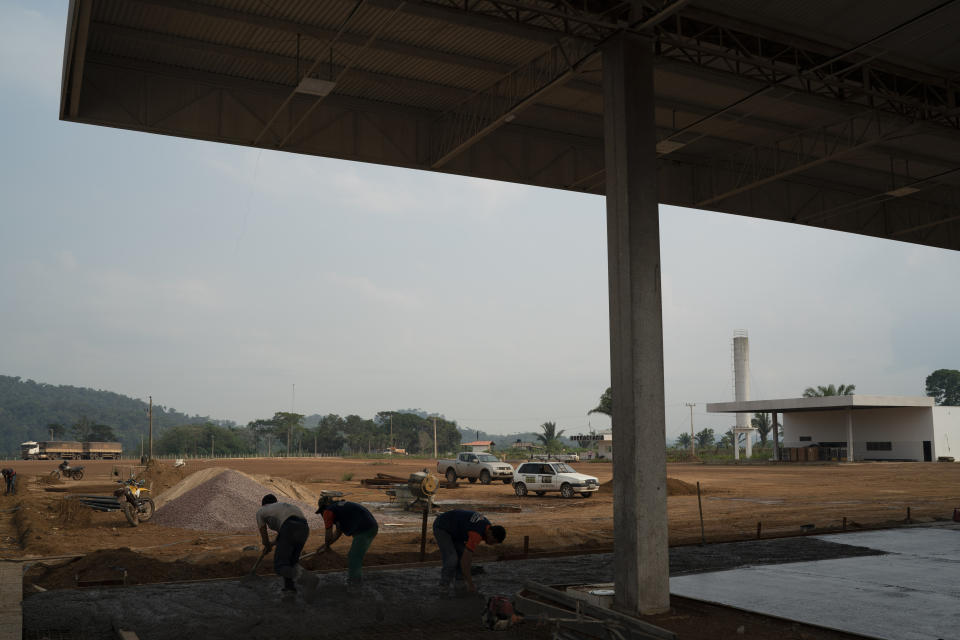 In this Nov. 29, 2019 photo, men work on the construction site of a gas station and parking lot on route BR-163 near the intersection with the Trans-Amazon highway in the area of Itaituba, Para state, Brazil. When it's complete, the parking area will be big enough for 760 trucks. (AP Photo/Leo Correa)