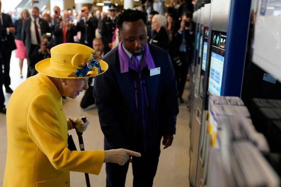 Queen Elizabeth II using an oyster card machine as she attends the Elizabeth line's official opening at Paddington Station.