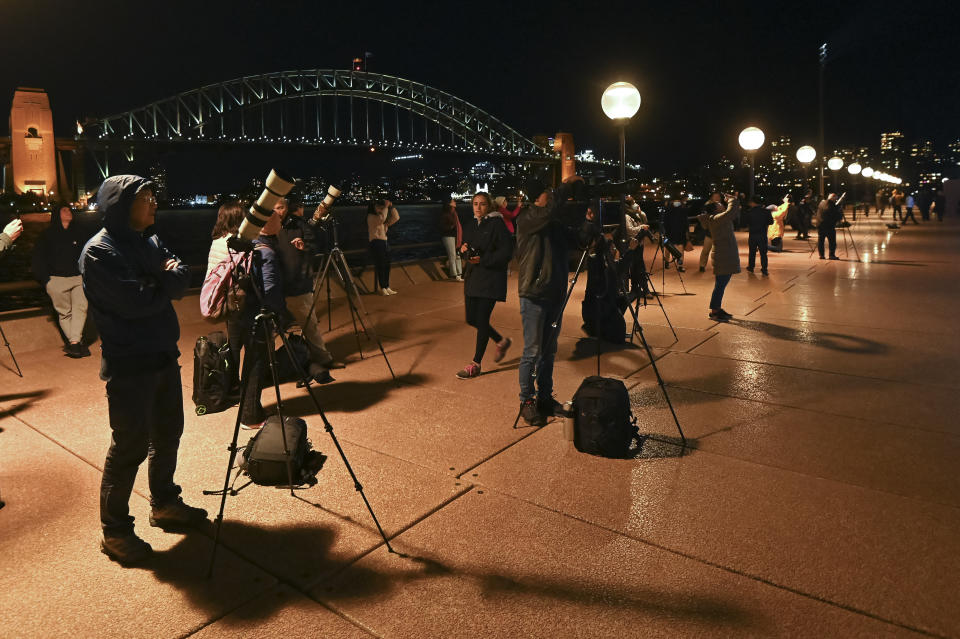 SYDNEY, AUSTRALIA - MAY 26: The Sydney Harbour Bridge can be seen as photographers, astronomers and star gazers observe the full moon, known as a âsuper flower blood moonâ, seen during its total lunar eclipse phase, in Sydney, Australia, on May 26, 2021. The full moon on Wednesday will be the year's biggest âsuper moonâ and feature the first total lunar eclipse in more than two years, known as a âsuper blood moonâ. A âsuper blood moonâ is when a total lunar eclipse (or âblood moonâ) happens at the same time as a âsuper moonâ, when the moon will be at perigee, or the closest point to Earth in its orbit, making it appear about 7% larger than normal and 15% brighter. The eclipse will be visible from Australia, New Zealand, the Pacific, South-East Asia and parts of North and South America at the same time. (Photo by Steven Saphore/Anadolu Agency via Getty Images)