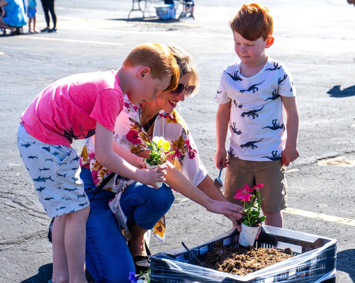 At Monroe County Intermediate School District's "Growing Abilities" event (from left) Sam, Allison and Jasper Buber plant flowers to take home.