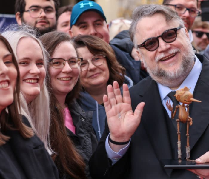 Guillermo con una figurita de Pinocchio y rodeado de fans