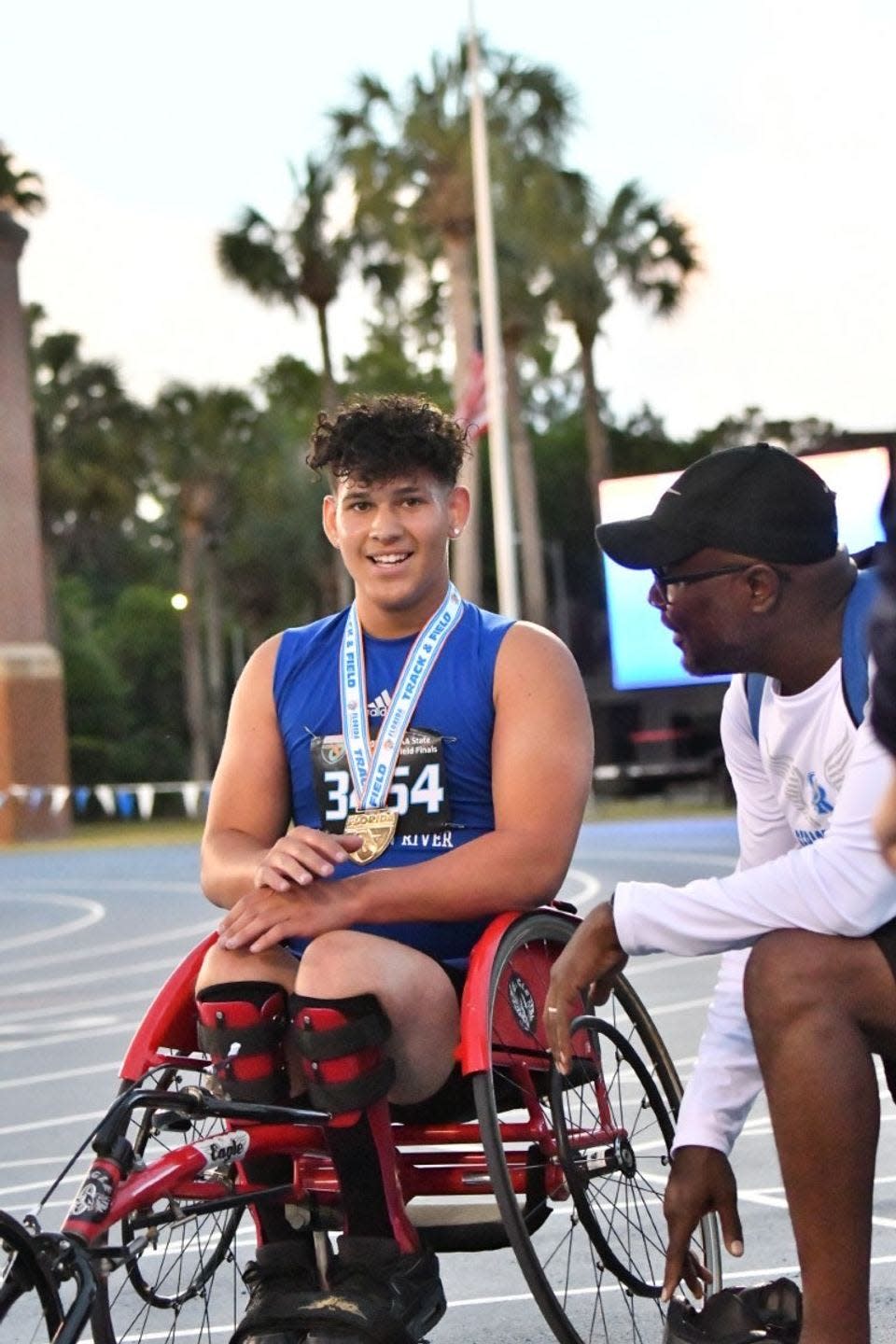 Sebastian River senior Aaron Pena and his coach Tony Flemming celebrate together during the FHSAA adaptive track and field championships back on May 14, 2022 at the University of Florida. Pena won both the 200 and 800-meter dash setting new personal best times in each race.