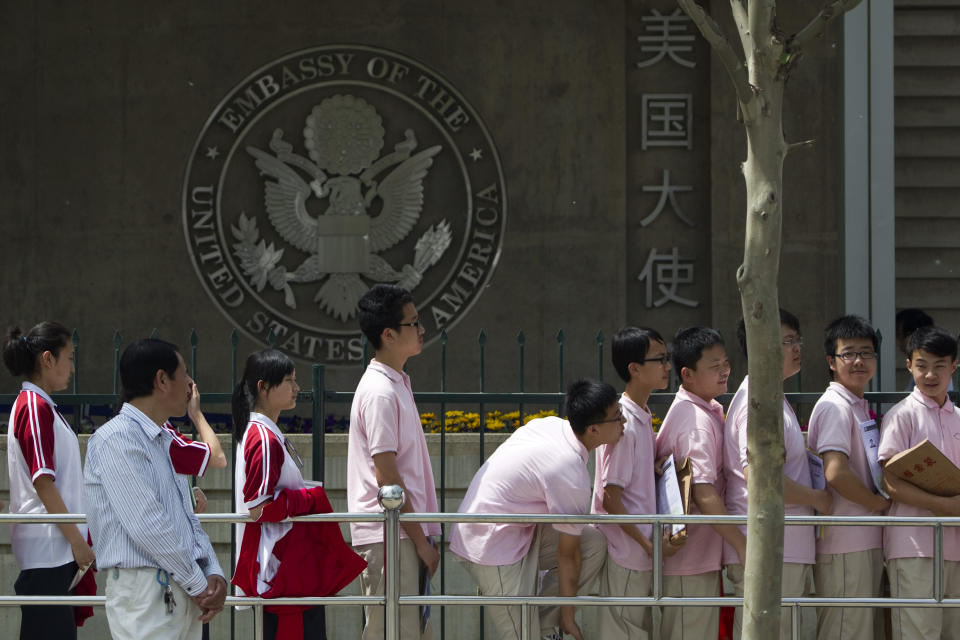 FILE - Chinese students wait outside the U.S. Embassy for their visa application interviews on May 2, 2012, in Beijing. Over the past four decades, U.S. universities have educated millions of Chinese students, many of whom have stayed in the country and become top researchers and distinguished professors. (AP Photo/Alexander F. Yuan, File)