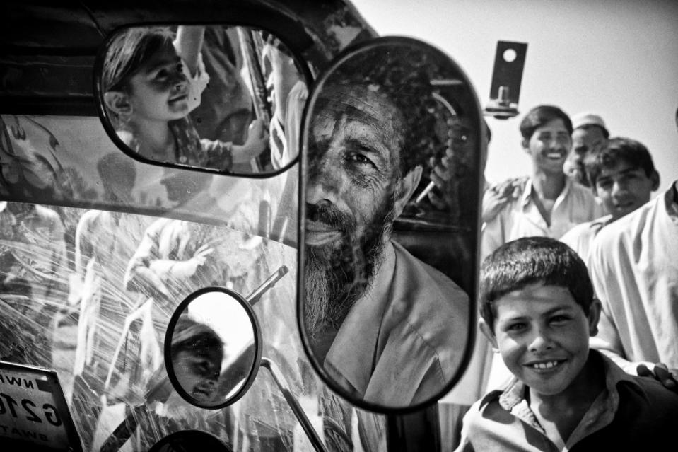 Sher Zaman, 50, squeezed 10 people into his LPG-powered auto-rickshaw, built to carry 3 passengers, to escape the conflict in  Swat valley. More than two million people fled in tractors, cattle trucks, auto-rickshaws, and whatever transport means they could find, as mortar shells pummeled their paradise. 2009/05/20.  Swat Valley was once known as the "Switzerland of the East", a paradise on earth. But in 2009, it was embroiled in a bloody conflict between the Taliban and the army. In 2010, a terrible flood obliterated everything that Man did not destroy. And in 2012, the teen activist Malala Yusufzai was shot in the head by extremist gunmen. In a land scourged many times over, its people of Swat continue their uphill task to rebuild  the paradise lost to both Man and Nature. Image Credit: Edwin Koo