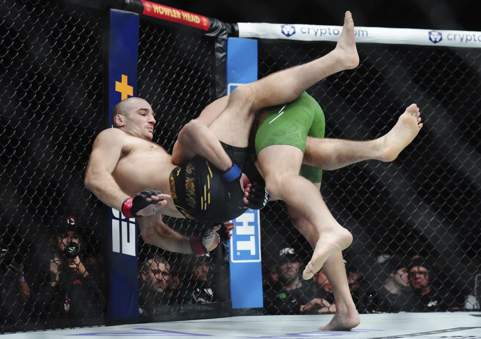 Sean Strickland, left, is taken down by Dricus Du Plessis during a middleweight title bout at UFC 297 in Toronto early Sunday, Jan. 21, 2024. (Nathan Denette/The Canadian Press via AP)