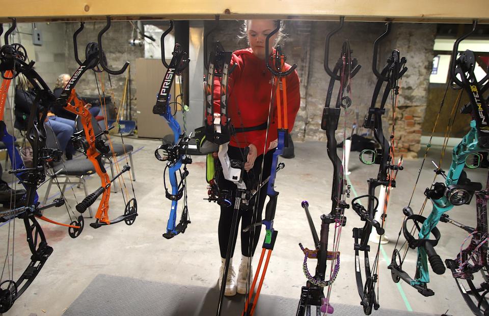 Katie Ettinger, 14, of Mount Pleasant hangs her boon on the rack at the Flint River Archery Club on Wednesday in Burlington.