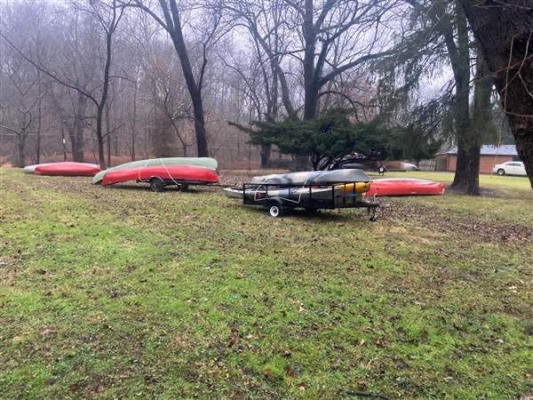 Rescue canoes sit ready along the swollen Neshaminy Creek near Periwinkle Avenue on Tuesday afternoon.