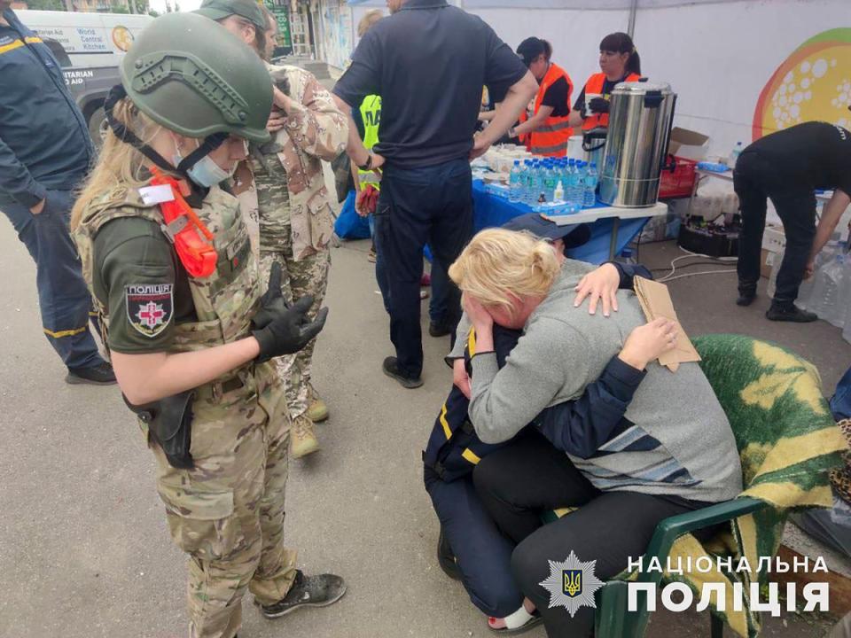 A psychologist of the State Emergency Service of Ukraine, centre, hugs a woman after the strike (AP)