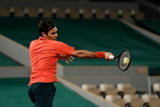 Roger Federer hits a forehand in front of an empty stadium