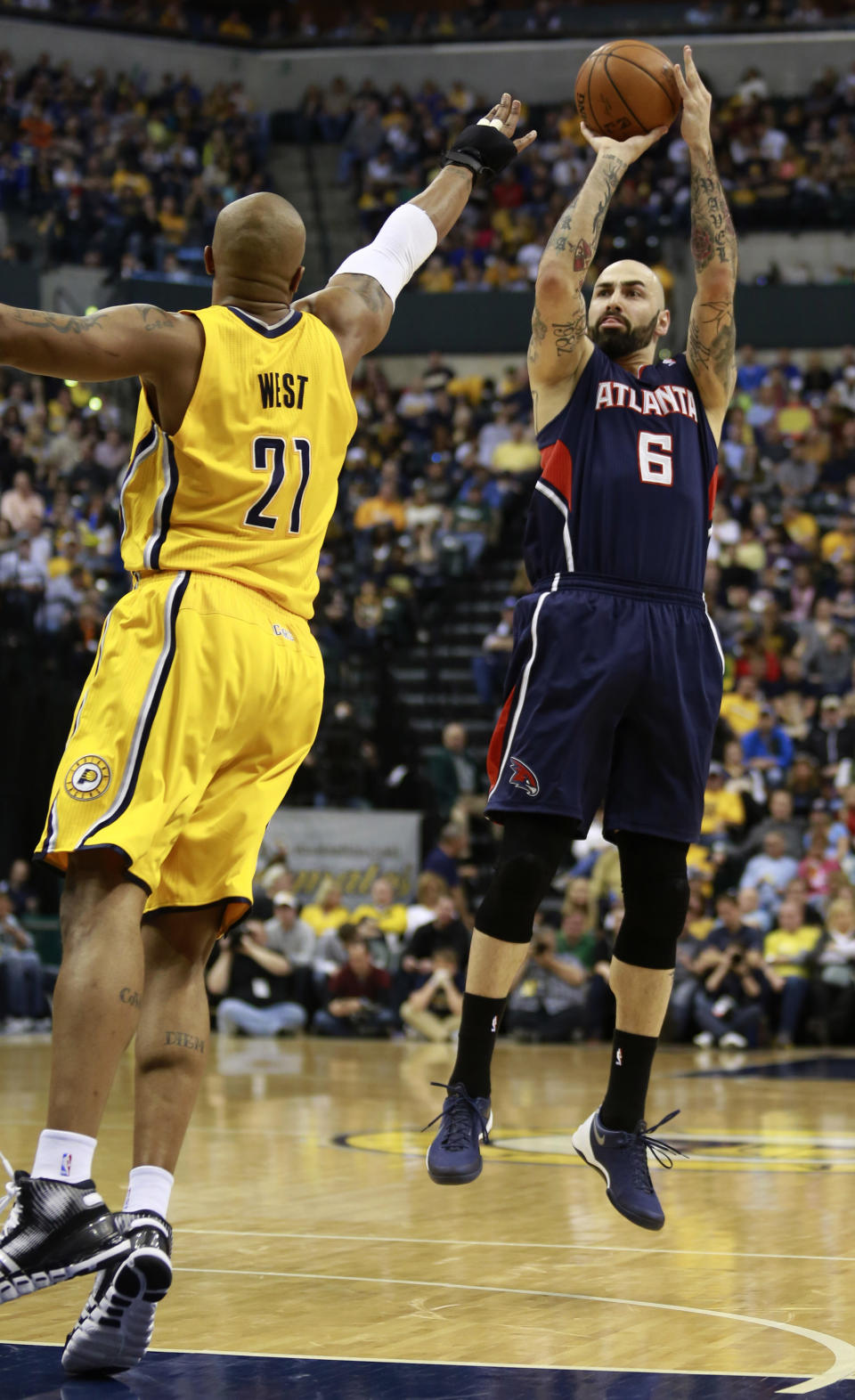 Atlanta Hawks center Pero Antic (6) shoots the basketball defended by Indiana Pacers forward David West in the first half of an NBA basketball game in Indianapolis, Sunday, April 6, 2014. (AP Photo/R Brent Smith)