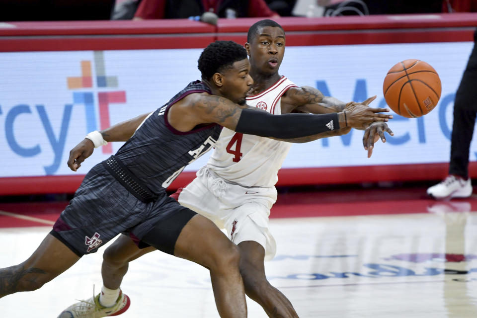 Texas A&M guard Jay Jay Chandler (0) tries to get past Arkansas guard Davonte Davis (4) during the first half of an NCAA college basketball game in Fayetteville, Ark., Saturday, March 6, 2021. (AP Photo/Michael Woods)