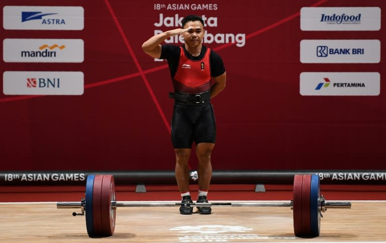 Eko Yuli Irawan salutes president Joko Widodo after winning gold in the men's 62kg weightlifting