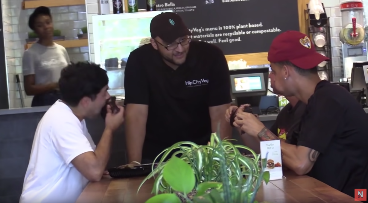 Three men eat meat in vegan restaurant