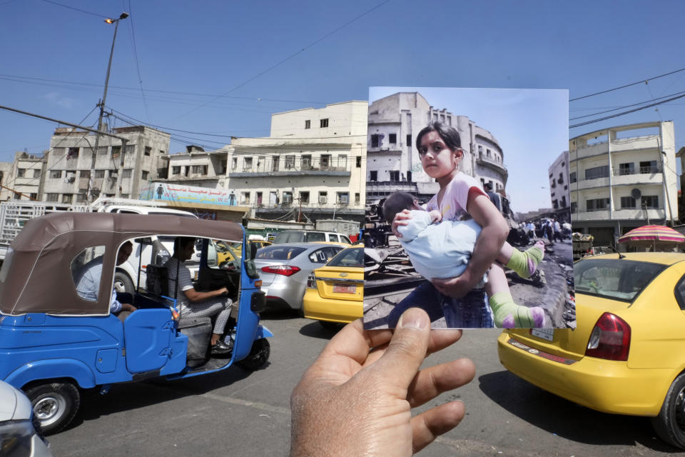 A photograph of a girl carrying a baby on the spot of the previous day's car bomb attack that killed killed and wounded hundreds at the Sadriyah market in Baghdad, Iraq, Thursday, April 19, 2007, is inserted into the scene at the same location on Monday, March 20, 2023, 20 years after the U.S. led invasion on Iraq and subsequent war. (AP Photo/Hadi Mizban)